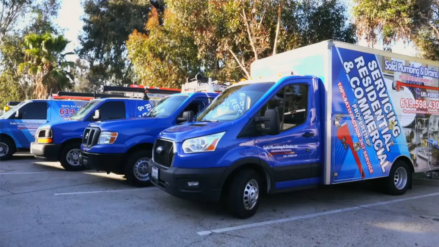 Plumbing service vehicles parked together.