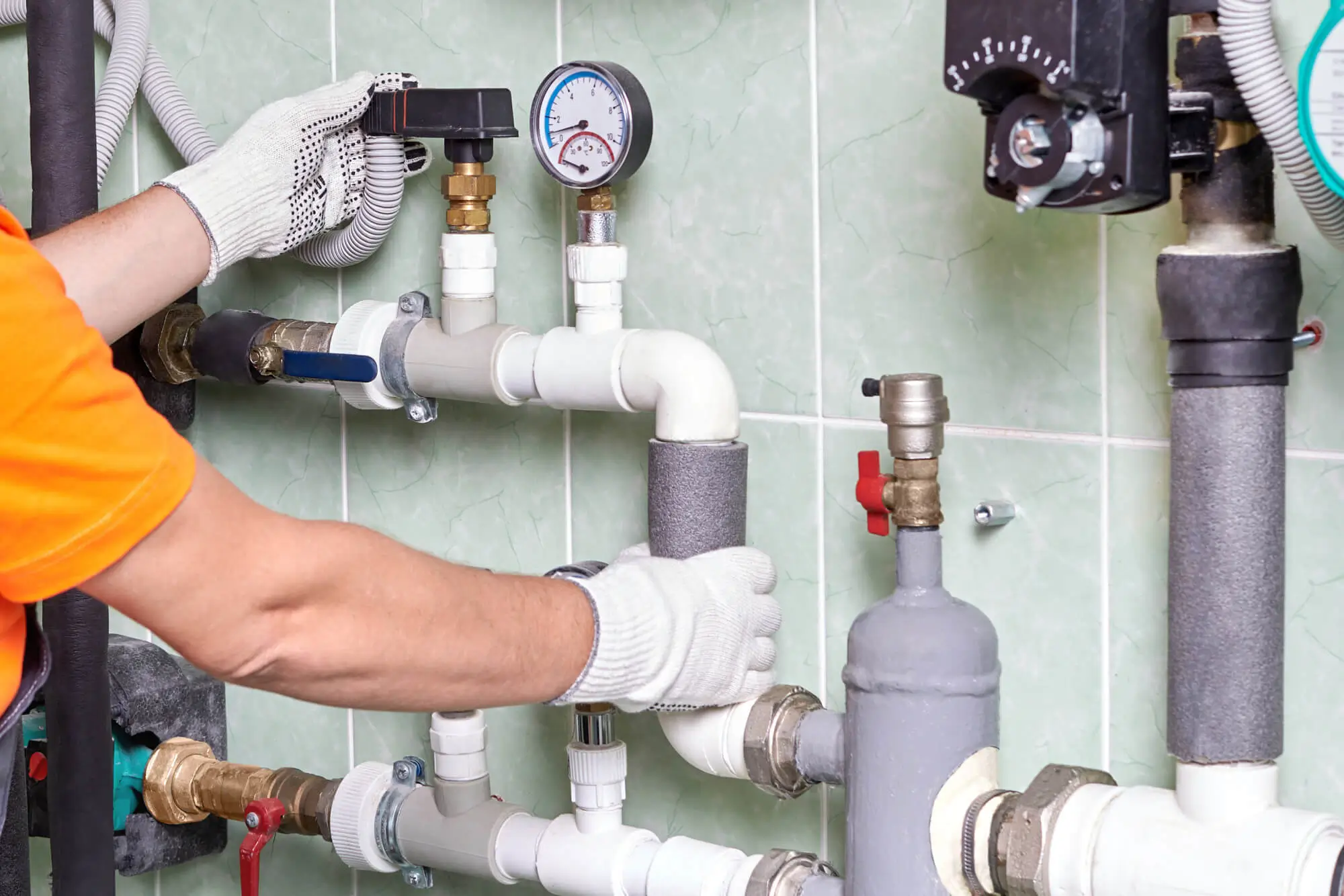 Plumber adjusting pipes and gauges.