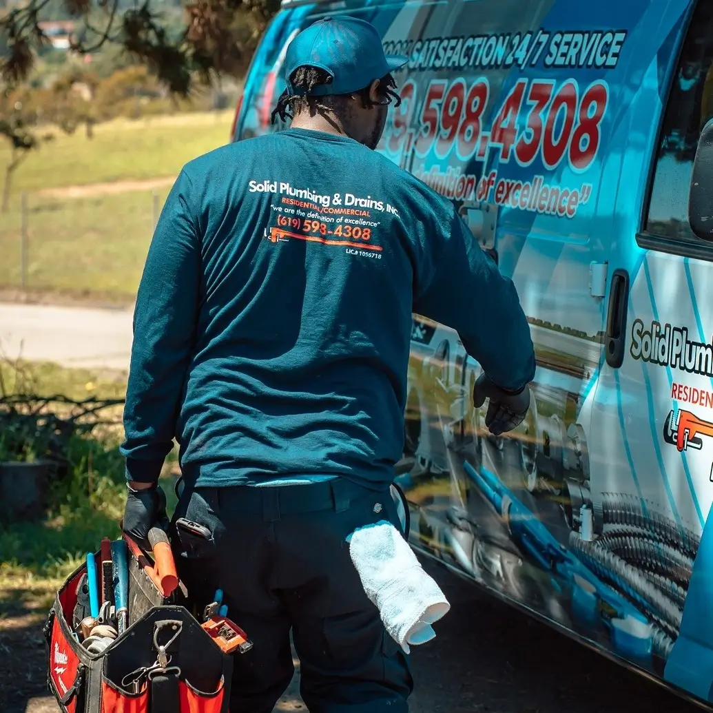 Solid Plumbing & Drains plumber working beside a service truck in San Diego