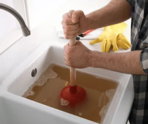 Using Plunger to Unclog Sink Drain in Kitchen, Closeup
