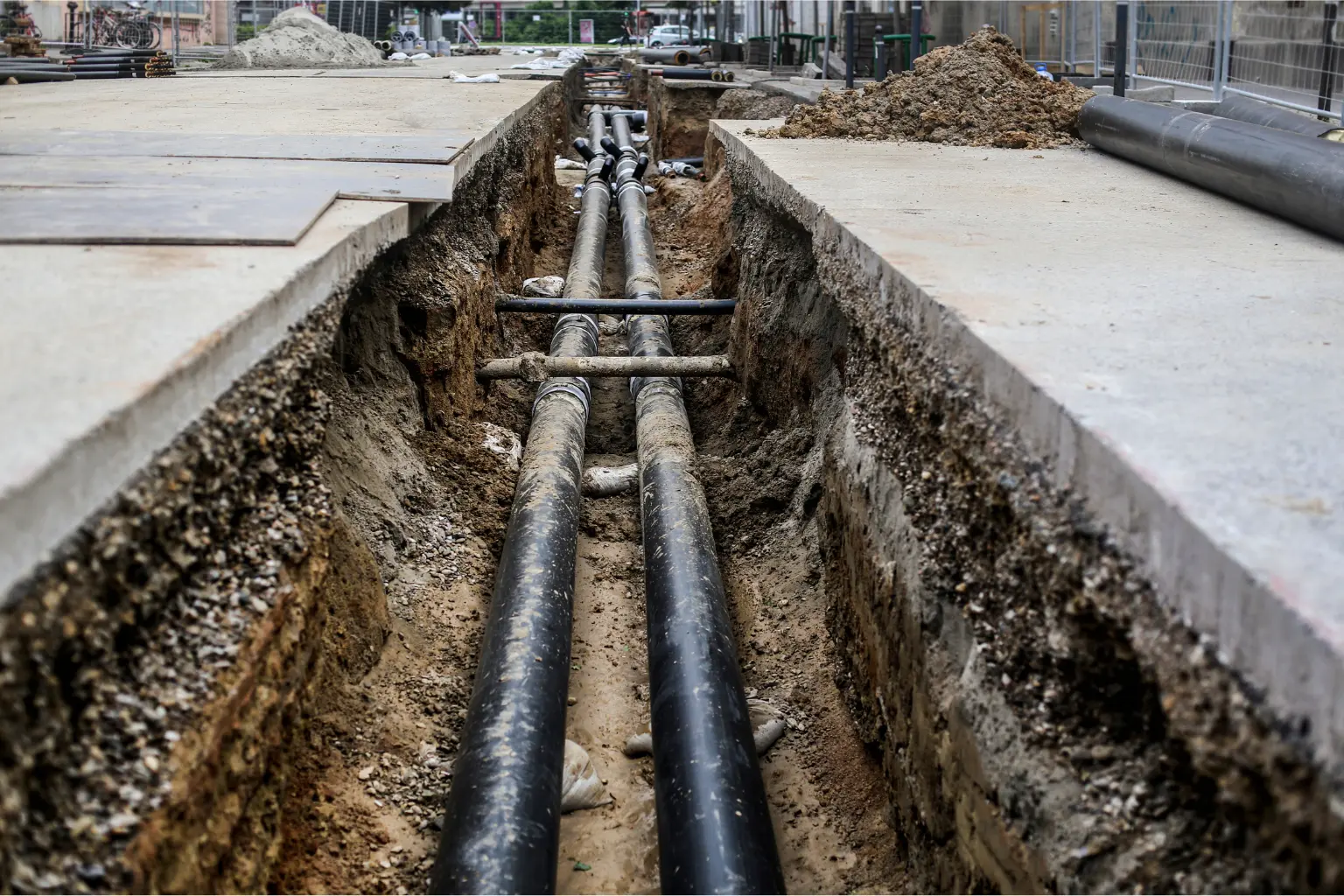 Underground commercial pipelines exposed in an excavation trench in San Diego.