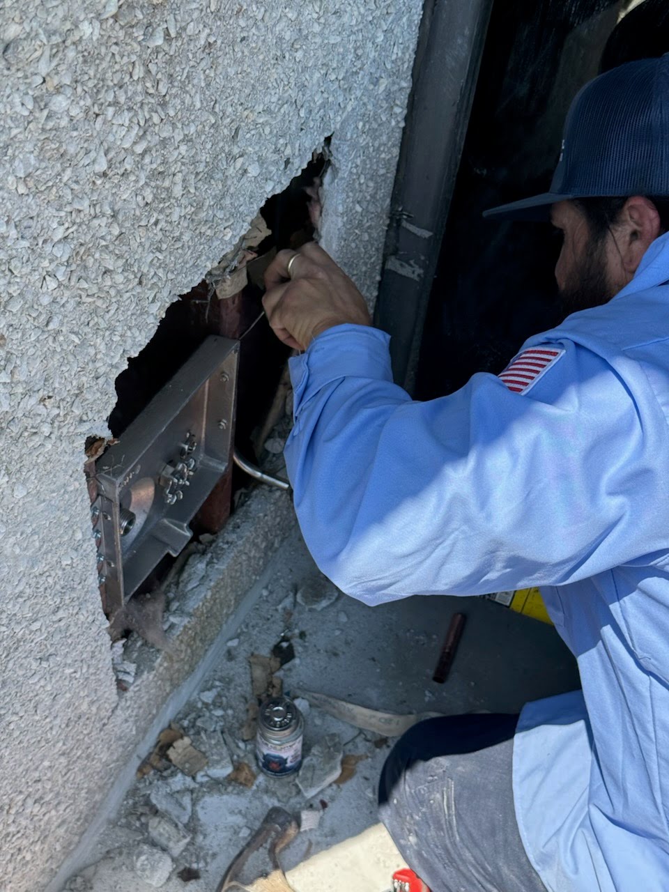 Plumber inspecting hidden plumbing inside a wall for needed repairs