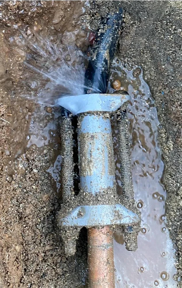 Burst pipe leaking water during an emergency plumbing situation