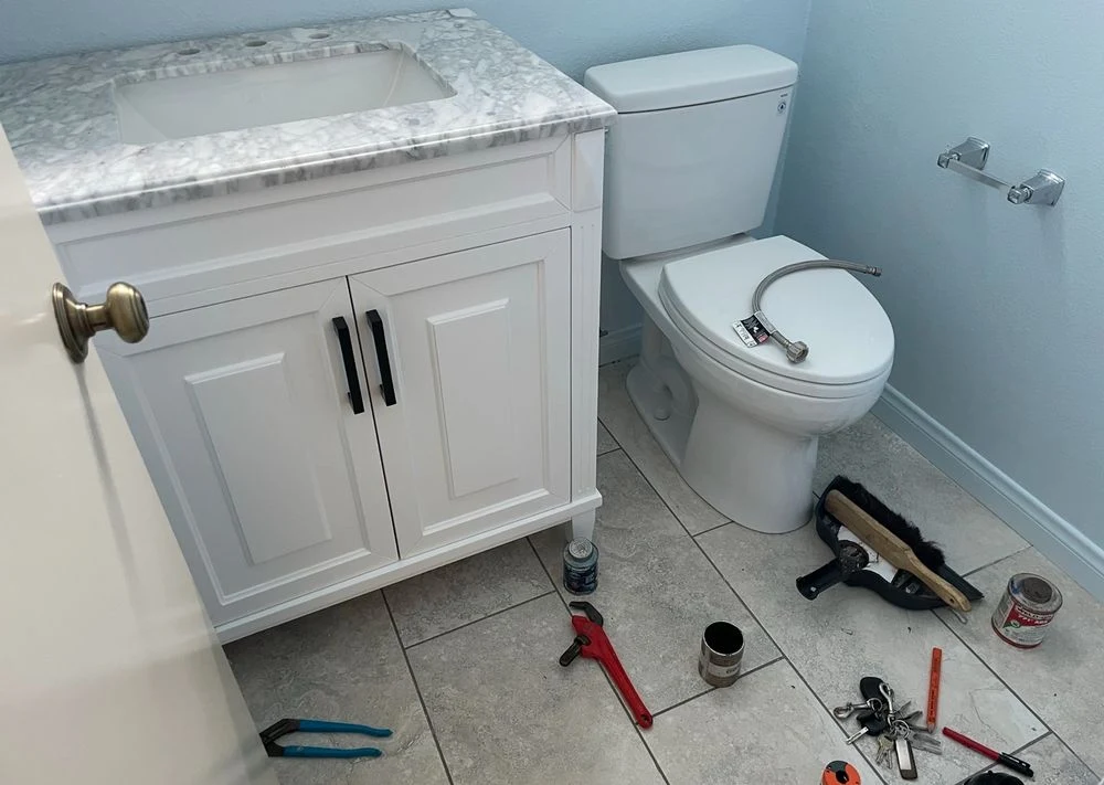 Residential plumber repairing a toilet and bathroom plumbing fixture