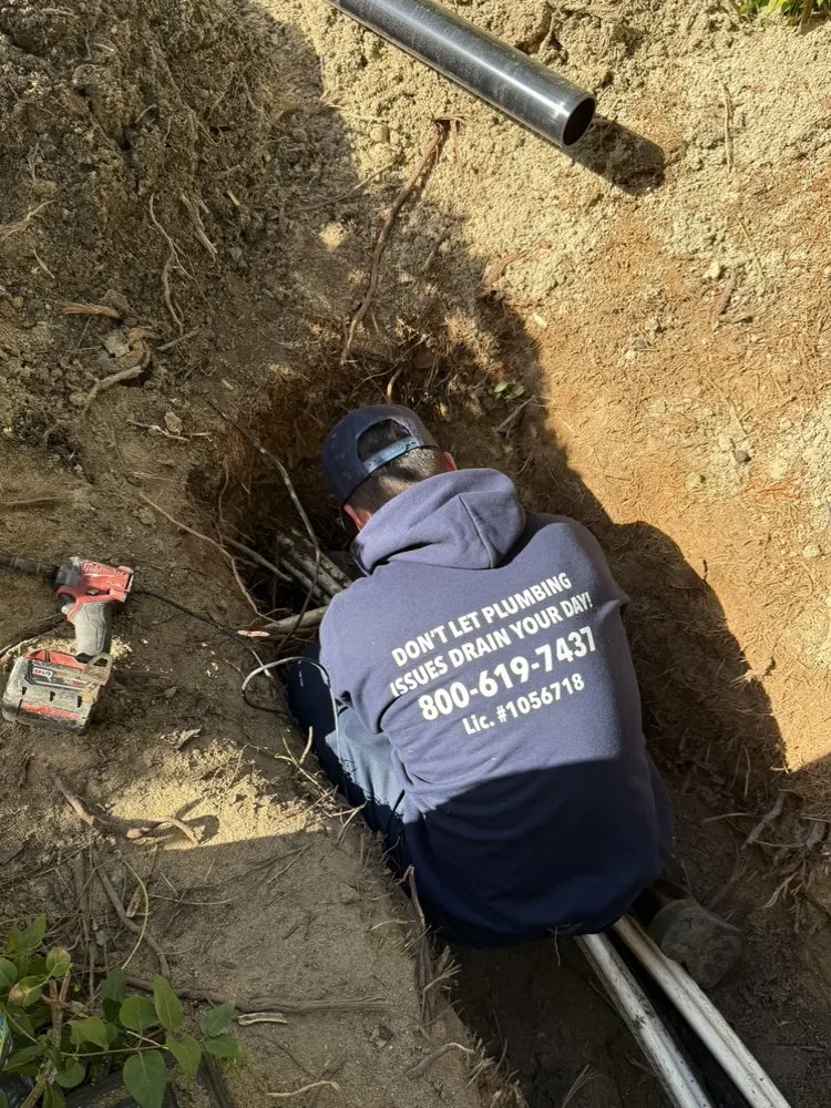 Plumber accessing an underground sewer line with tree root intrusion